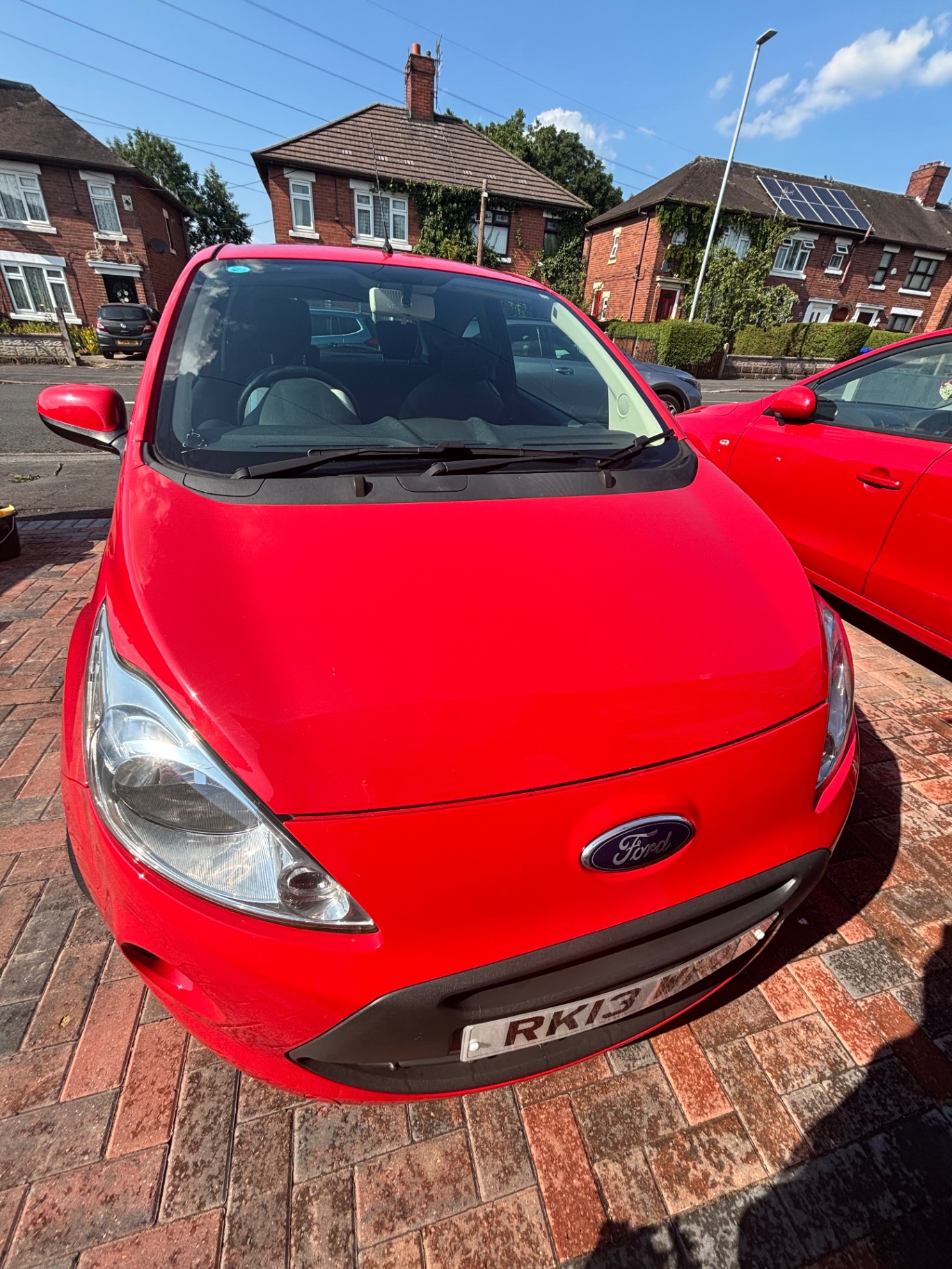 Red Ford hatchback with a glossy clean finish after an exterior detail